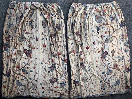 A pair of 1920s silk lined crewel work curtains, 7ft 10ins long